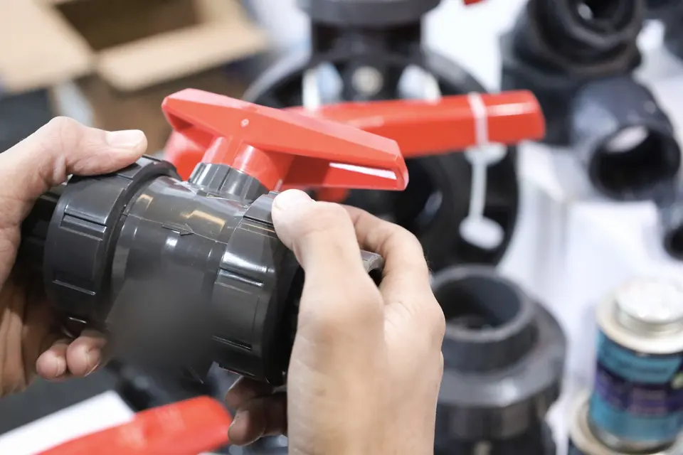 Hands Inspecting Industrial Valve at Exhibition